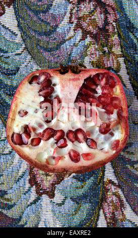 Dimezzato il melograno organico sul tavolo da pranzo Foto Stock