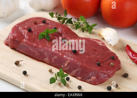 Preparare il cibo crudo di carne di manzo bistecca su una tavola di legno Foto Stock