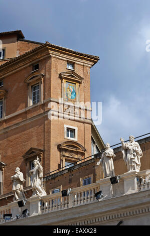 Una pittura religiosa sulla parete esterna dell'edificio e santamente figure sul colonnato presso la Città del Vaticano, Roma, Italia. Foto Stock