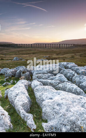 Il sole tramonta dietro Ribberhead viadotto nello Yorkshire Foto Stock