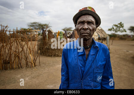 Un villaggio Turkana chief indossare tuta di caldaia, Kenya Foto Stock