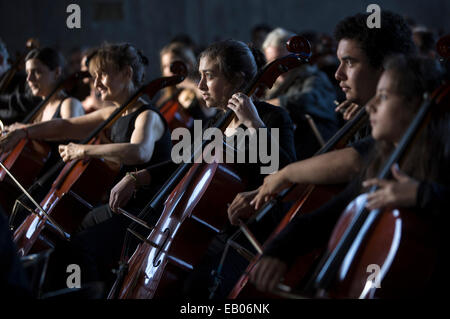 Buenos Aires, Argentina. 22 Novembre, 2014. Violoncellisti giocare una improvvisata melodia, diretto dal violoncellista Claudio Pena, durante l'ensemble "100 violoncelli', nel contesto della celebrazione del 'Day della musica', nel cortile della biblioteca nazionale, nella città di Buenos Aires, capitale dell'Argentina il 9 novembre 22, 2014. © Mart¨ªn Zabala/Xinhua/Alamy Live News Foto Stock