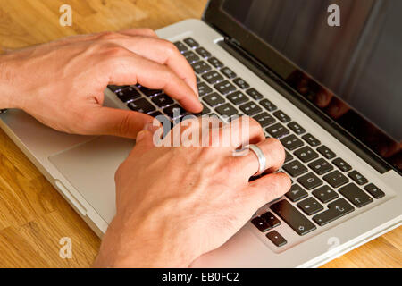Chiudere fino a mani uomo multitasking utilizzando laptop wifi connessione Foto Stock