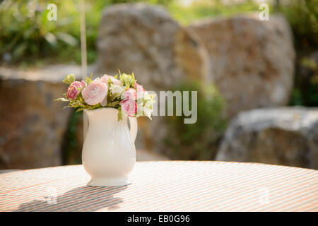 Fiori artificiali e piante secche in vasi trasparenti sul pavimento contro  parete blu Foto stock - Alamy