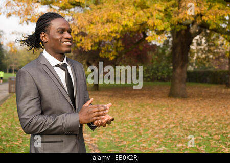 Business man battimani incoraggiando i suoi compagni di squadra in un team building esercizio Foto Stock