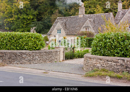 Una vista un bel cottage in Bibury con girasoli in giardino Foto Stock