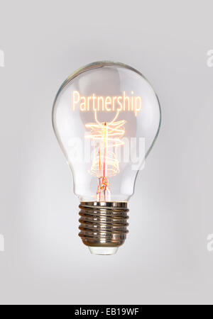 Il concetto di partenariato in un filamento lampadina. Foto Stock