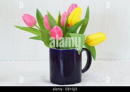 Rosa e tulipani gialli in blu navy mug Foto Stock