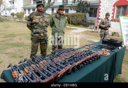 Srinagar Kashmir. 24 Novembre, 2014. Un esercito indiano officer ispeziona un Ak 47 fucili per la visualizzazione delle armi e delle munizioni presso il quartier generale dell'esercito a Srinagar, secondo notizie, esercito indiano rivendicato il recupero di armi e munizioni da un sospetto militante nascondiglio domenica, in prossimità della linea di controllo, la linea che divide il Kashmir tra India e Pakistan, in vista delle elezioni di domani 25 novembre. Credito: sofi suhail/Alamy Live News Foto Stock