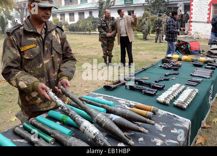 Srinagar Kashmir. 24 Novembre, 2014. Un esercito indiano officer ispeziona un Ak 47 fucili per la visualizzazione delle armi e delle munizioni presso il quartier generale dell'esercito a Srinagar, secondo notizie, esercito indiano rivendicato il recupero di armi e munizioni da un sospetto militante nascondiglio domenica, in prossimità della linea di controllo, la linea che divide il Kashmir tra India e Pakistan, in vista delle elezioni di domani 25 novembre. Credito: sofi suhail/Alamy Live News Foto Stock