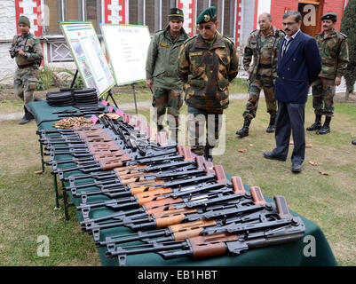 Srinagar Kashmir. 24 Novembre, 2014. Un esercito indiano officer ispeziona un Ak 47 fucili per la visualizzazione delle armi e delle munizioni presso il quartier generale dell'esercito a Srinagar, secondo notizie, esercito indiano rivendicato il recupero di armi e munizioni da un sospetto militante nascondiglio domenica, in prossimità della linea di controllo, la linea che divide il Kashmir tra India e Pakistan, in vista delle elezioni di domani 25 novembre. Credito: sofi suhail/Alamy Live News Foto Stock