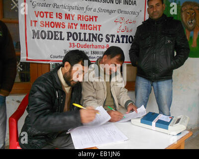 Srinagar Kashmir. 24 Novembre, 2014. Dipendente Goverrnment cheks voto elettronico macchina (EVM) come paramilitari indiano troopers guardia out polling laterale sia al distretto di ganderbal una ventina di chilometri da qui sicurezza potenziata sul primo gruppo di fase elezioni di domani 25 novembre. Credito: sofi suhail/Alamy Live News Foto Stock