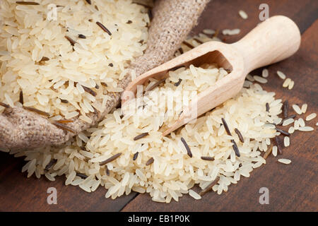 Riso nel sacco di tela con cucchiaio in legno Foto Stock