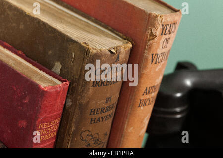 Vintage libri contro la parete verde con telefono in background Foto Stock