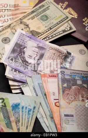 Moneta note, dollaro US, dollaro neozelandese, Ringitts Malesi, sterline inglesi, euro e passaporto irlandese Foto Stock
