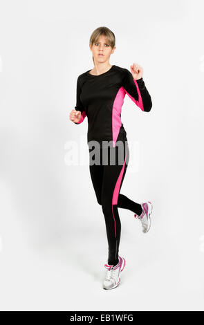 Femmina caucasica jogging, presa su sfondo bianco Foto Stock