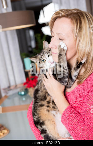 Una donna con un gatto in cucina Foto Stock