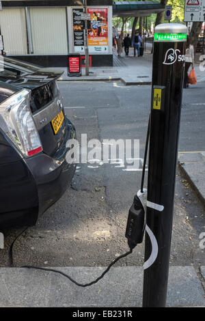 La Toyota Prius in carica in corrispondenza di un 'Source London' street punto di carica. Foto Stock