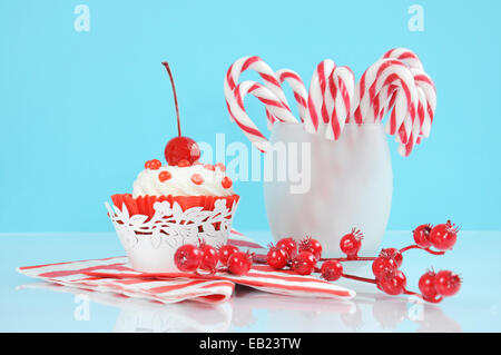 Vacanze di Natale dolce festa candy canes con cupcake in moderno rosso e bianco sulla tendenza di blu pallido e sfondo bianco. Foto Stock