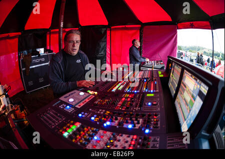 Uomini al lavoro sull'illuminazione e audio di banchi di controllo al grande tributo music festival Aberystwyth Regno Unito a Ferragosto 2014 Foto Stock