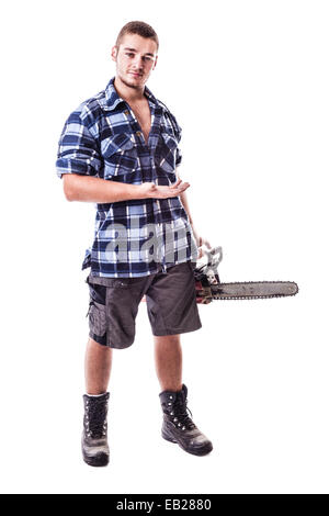 Un giovane taglialegna che indossa una camicia a scacchi tenendo un chainsaw e mostrando qualcosa di isolato su sfondo bianco Foto Stock