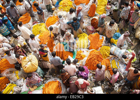 Vista aerea del mercato dei fiori brulicante di attività e sacco sacchi pieni di fiori colorati e ghirlande con i venditori a quella di Howrah Bridge, Calcutta, India Foto Stock