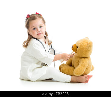 Adorable kid vestito come medico a giocare con il giocattolo su bianco Foto Stock