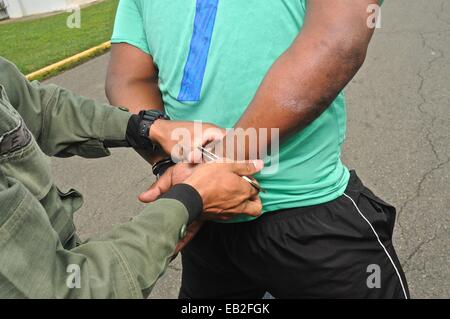 In uniforme degli ufficiali di polizia a una tattica e armi e corso di formazione al Panamanian forza nazionale di polizia Accademia pratica di un arresto. Foto Stock
