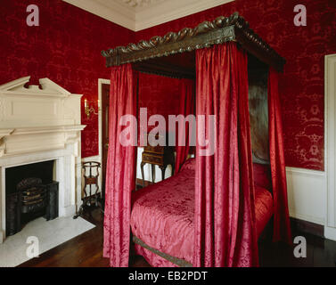 Il damasco rosso Bedchamber mostra il letto e camino, Marble Hill House, Twickenham, Surrey, Regno Unito Foto Stock