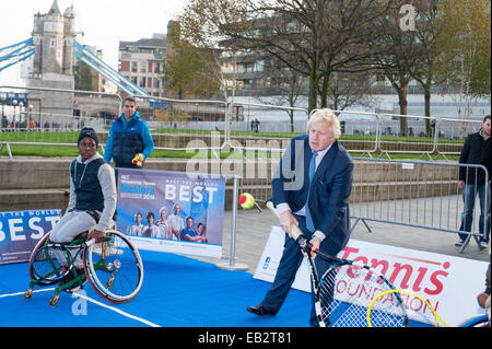 Il Municipio, la Queen's Walk, London, Regno Unito. Il 24 novembre 2014. Il sindaco di Londra Boris Johnson, si unisce con alcuni dei migliori del mondo di tennis in carrozzella giocatori come hanno dimostrato le proprie competenze al di fuori del Municipio in vista del prossimo NEC Tennis in carrozzina maestri. Foto Stock