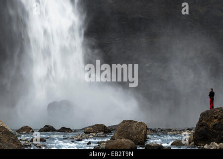 Un turista è in piedi accanto alla cascata Haifoss sul Fossá í Thjósárdal fiume valle Thjorsardalur, Regione meridionale Foto Stock