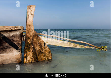 Il legno intagliato timone, montante e il telone vela del legno di un trimarano dhow pesca ormeggiate nei bassifondi. Foto Stock