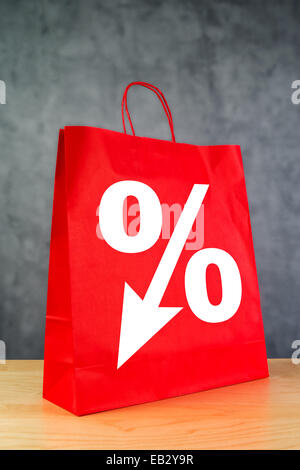 Percentuale di sconto sul simbolo rosso Shopping Bag su legno Store TAVOLO. Foto Stock