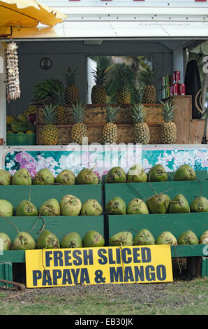 Una frutta stand con noci di cocco e di ananassi in vendita. Foto Stock
