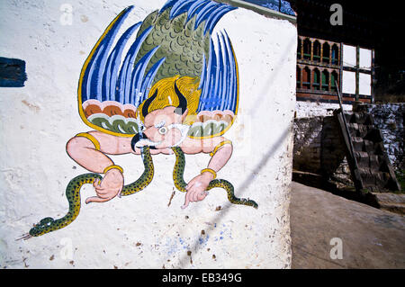 Un murale colorato di Garuda mangiare un serpente sulla parete di una casa vicino a un monastero buddista. Foto Stock