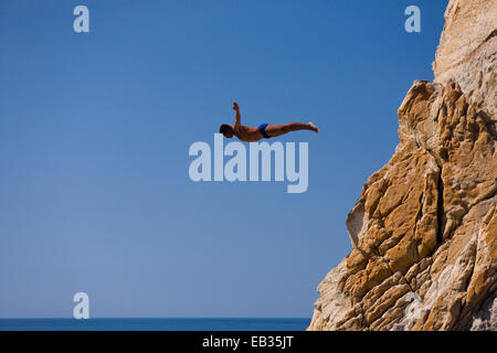 Clavadista o cliff diver salta fuori la scogliera di La Quebrada, Acapulco, Guerrero, Messico Foto Stock