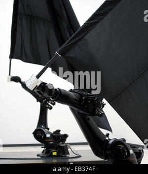 Dresden, Germania. 25 Nov, 2014. Due robot industriali gigante onda bandiere nere nella mostra 'William Forsythe Bandiere nere' nel cubo bianco alla Kunsthalle di Lipsiusbau a Dresda, Germania, 25 novembre 2014. La mostra nella Galleria dei Nuovi Maestri si svolge in collaborazione con la American Danzatrice, coreografa e artista Forsythe e 'l'Forsythe Company." è sul display dal 27 Novembre 2014 fino al 11 gennaio 2015. Credito: dpa picture alliance/Alamy Live News Foto Stock