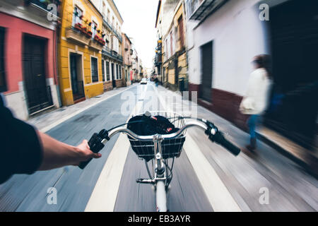 Prospettiva personale di una persona che pedalando attraverso la città Foto Stock