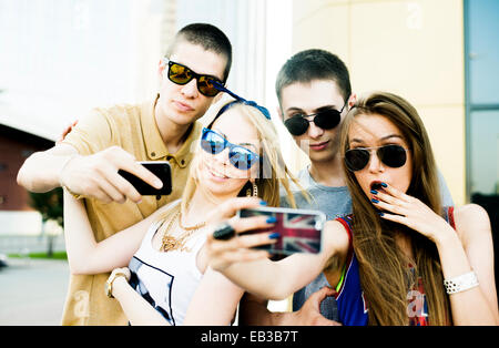 Coppie caucasica tenendo selfie all'aperto Foto Stock