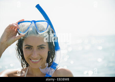 Caucasian donna che indossa lo snorkel e maschera in ocean Foto Stock