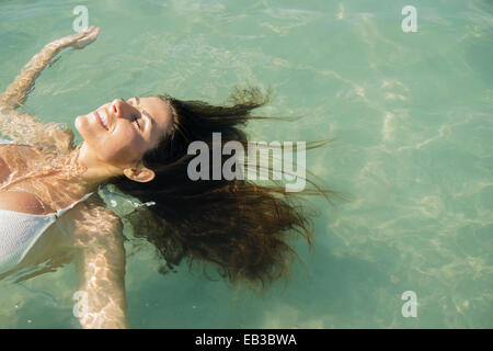 La donna caucasica galleggianti in ocean Foto Stock