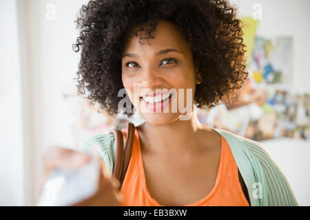 Donna sorridente con pagamento tramite carta di credito Foto Stock