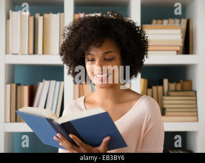 Donna libro di lettura in biblioteca Foto Stock