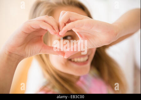 Ragazza caucasica messa a forma di cuore con le mani Foto Stock