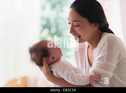 Asian madre holding baby Foto Stock