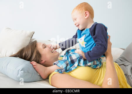 Caucasian madre e figlio giocando sul letto Foto Stock