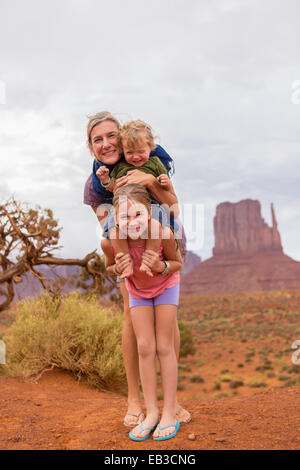 Famiglia caucasica sorridente nel deserto, Monument Valley, Utah, Stati Uniti Foto Stock