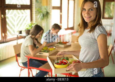 Studente portante vassoio pranzo in mensa scolastica Foto Stock
