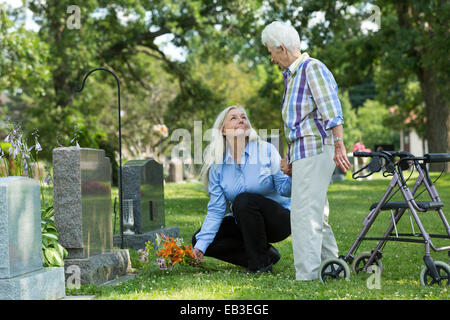 Caucasian madre e figlia visita tomba nel cimitero Foto Stock