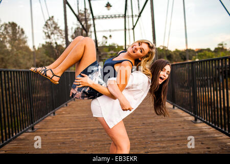 Caucasian ragazze adolescenti giocando sul ponte di legno Foto Stock
